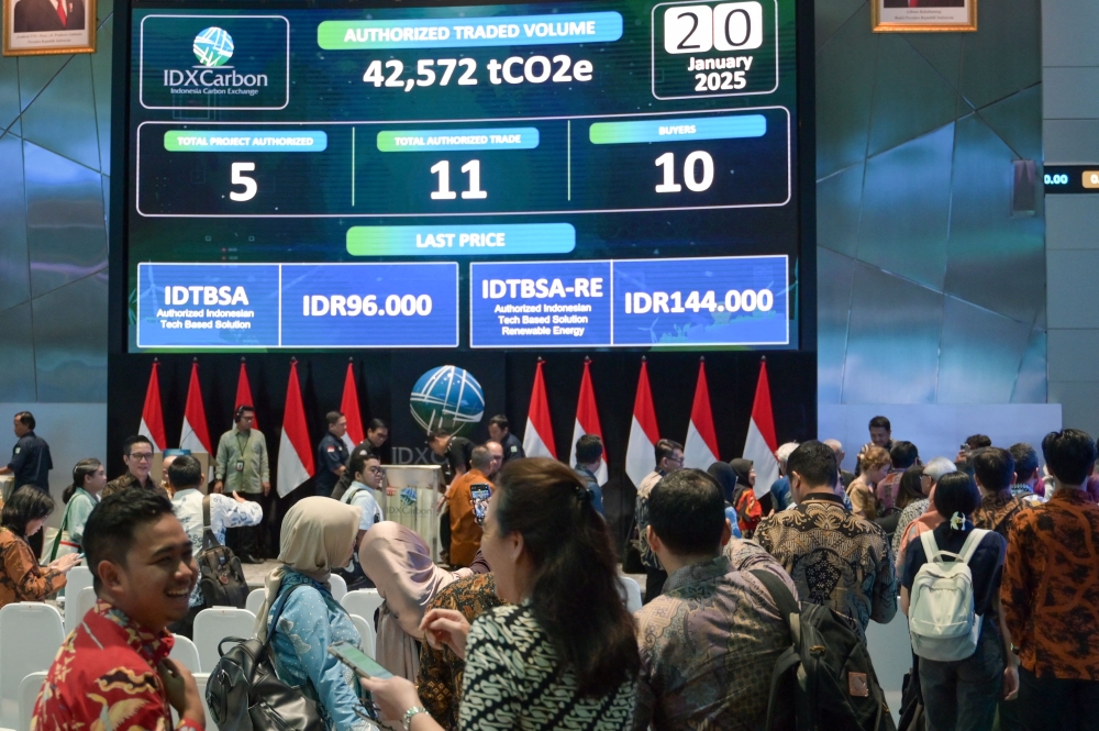 People watch carbon trading activity on a digital screen at the Indonesian stock exchange building in Jakarta on January 20, 2025. (Photo by Bay Ismoyo / AFP)