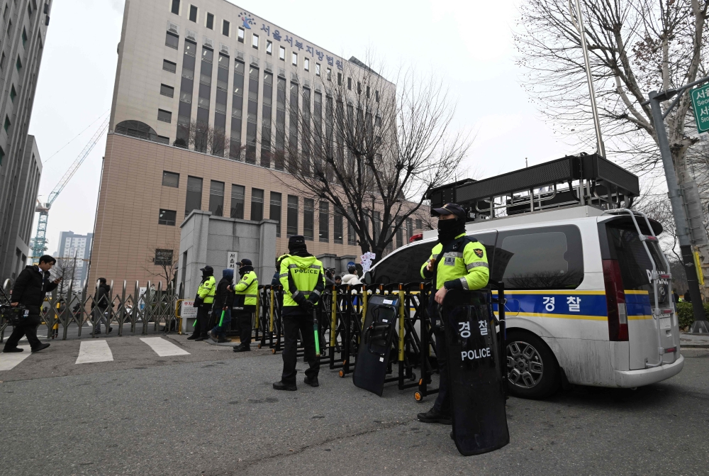 Policemen stand guard in front of the main gate at the Seoul Western District Court in Seoul on January 20, 2025, after supporters of South Korean President Yoon Suk Yeol stormed the building on January 19. (Photo by Jung Yeon-je / AFP)