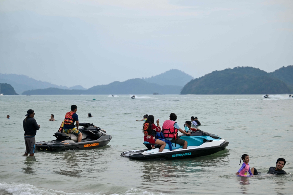 Visitors rent jet skis at Pantai Cenang in Malaysia's Langkawi Island on January 19, 2025. (Photo by Mohd Rasfan / AFP)