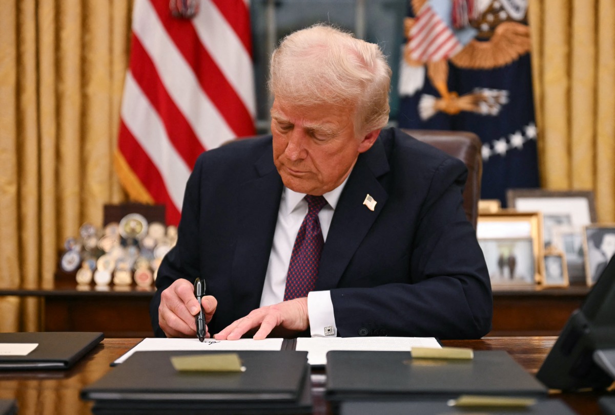 US President Donald Trump signs executive orders in the Oval Office of the White House in Washington, DC, on January 20, 2025. Photo by Jim WATSON / POOL / AFP.
