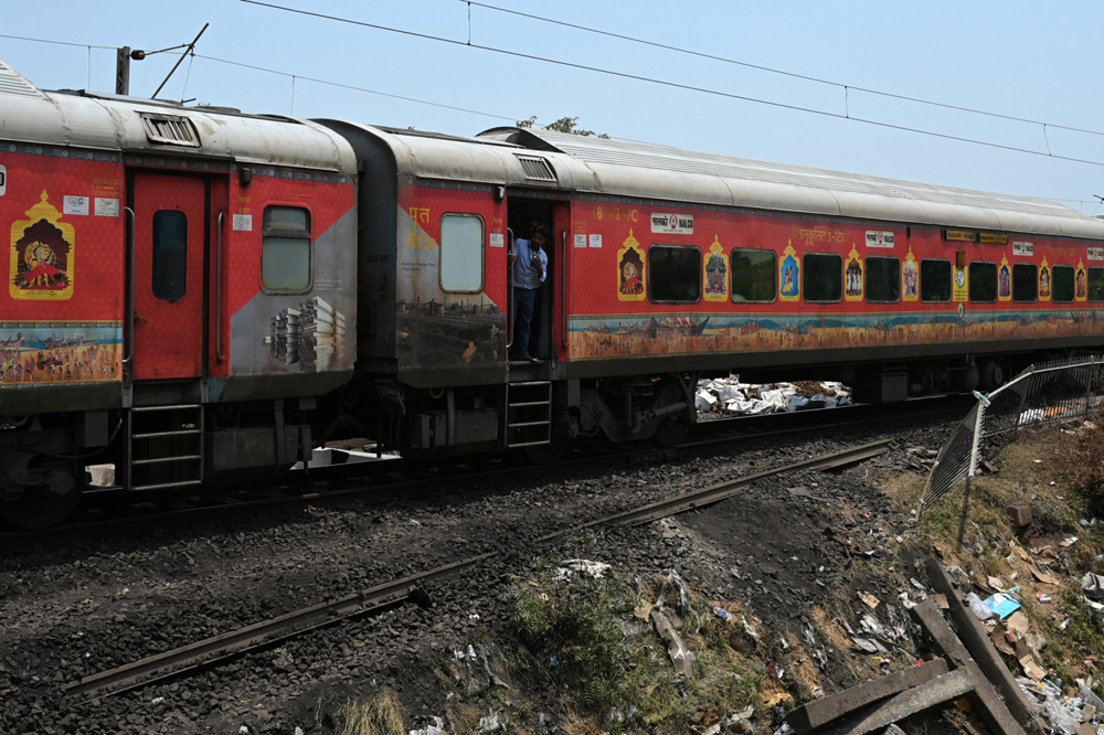 File photo for representation only. A passenger looks out from a carriage of a long-distance train in India. (Punit PARANJPE / AFP)