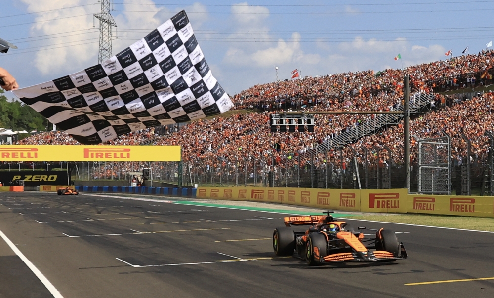 McLaren's Australian driver Oscar Piastri takes the chequered flag of the Formula One Hungarian Grand Prix at the Hungaroring race track in Mogyorod near Budapest on July 21, 2024. (Photo by MARTIN DIVISEK / POOL / AFP)

