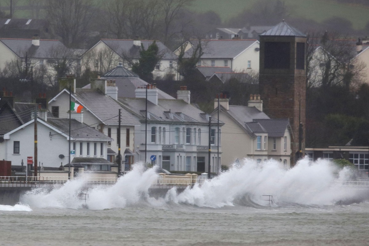 Waves break against the sea wall in Carnlough on the north east coast of Northern Ireland early in the morning of January 24, 2025, as storm Eowyn brings winds of 100 mph to the UK and Ireland. (Photo by PAUL FAITH / AFP)