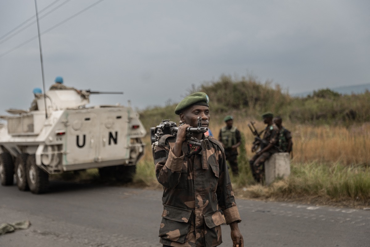 Uruguayan soldiers members of the United Nations Organization Stabilization Mission in the Democratic Republic of the Congo (MONUSCO) drive towards Goma as a soldier of the Armed forces of the Democratic republic of Congo (FARDC) walks along the road leading to the entrance of the town of Sake, 25km north-west of Goma, on January 23, 2025. Photo by Michael Lunanga / AFP.