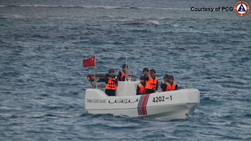 In this handout photo taken on January 24, 2025, China Coast Guard officers check an incident with Philippine Bureau of Fisheries and Aquatic Resources (BFAR) during a marine scientific survey near Thitu Island. (Photo by Handout / Philippine Coast Guard (PCG) / AFP) 