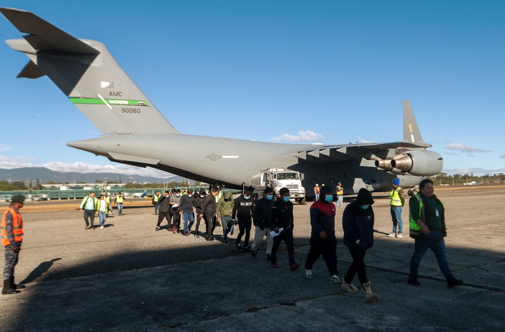 Handout picture released by Guatemalan Migration Institute shows Guatemalan migrants descending from an US military plane after being deported from US on January 24, 2025. (Photo by Handout / Guatemalan Migration Institute / AFP) 