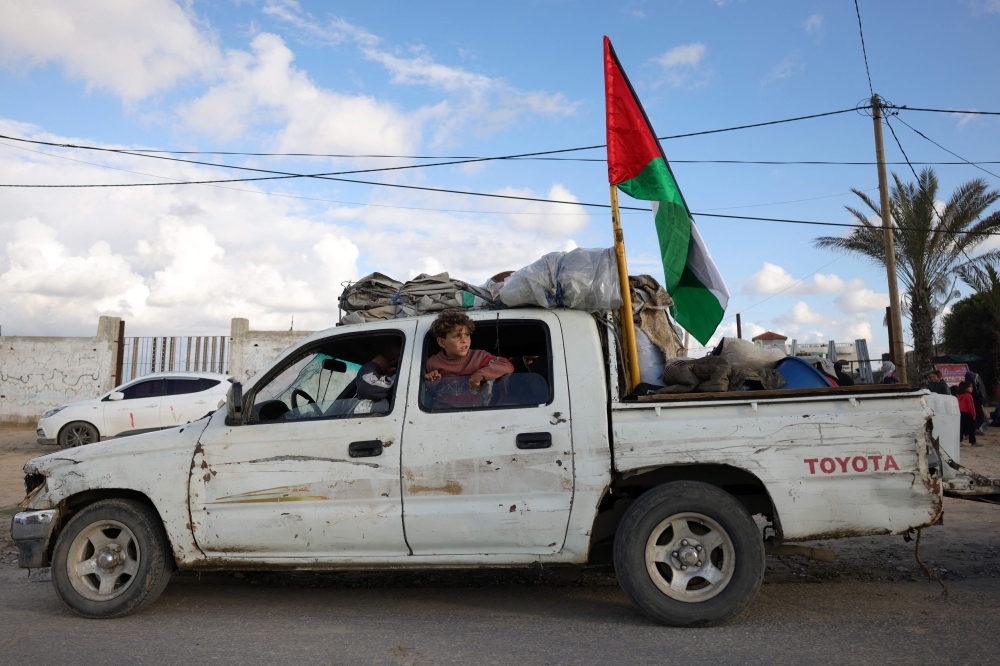 Displaced Palestinians arrive with their belongings northwest of Nuseirat in the central part of the strip on January 24, 2025. (Photo by Bashar Taleb / AFP)