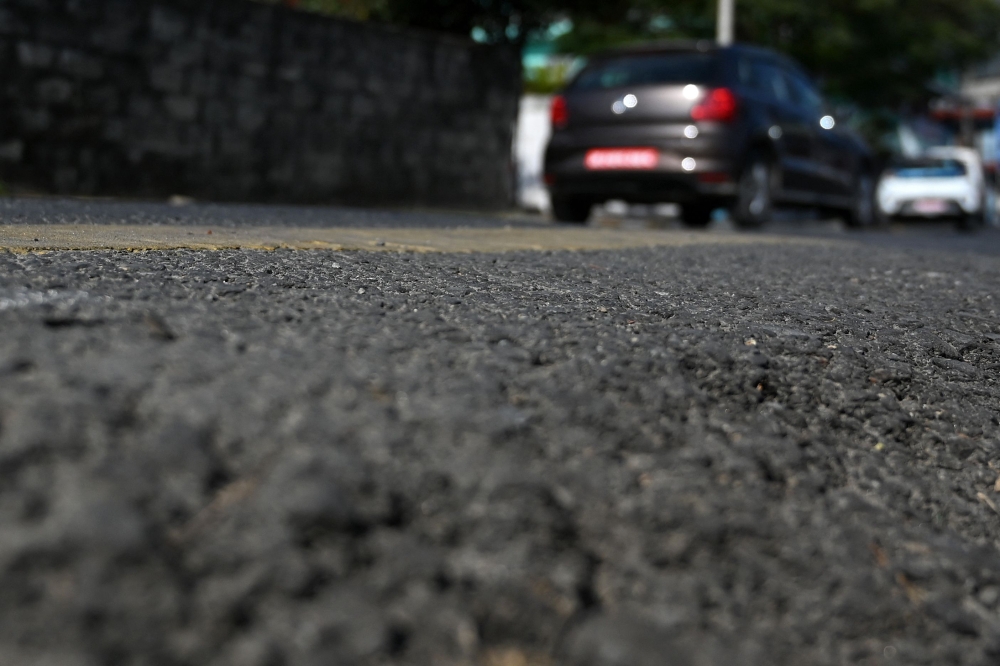 This photograph taken on December 26, 2024 shows vehicles riding over a road built using recycled plastic waste in Pokhara. (Photo by Prakash Mathema / AFP) 