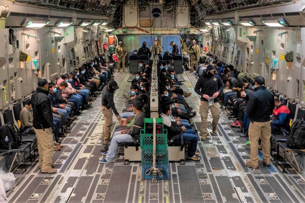 This image released by the Department of Defense shows undocumented migrants awaiting takeoff for a removal flight at the Tucson International Airport, Arizona, January 23, 2025. (Photo by Devlin Bishop / DVIDS / AFP)
