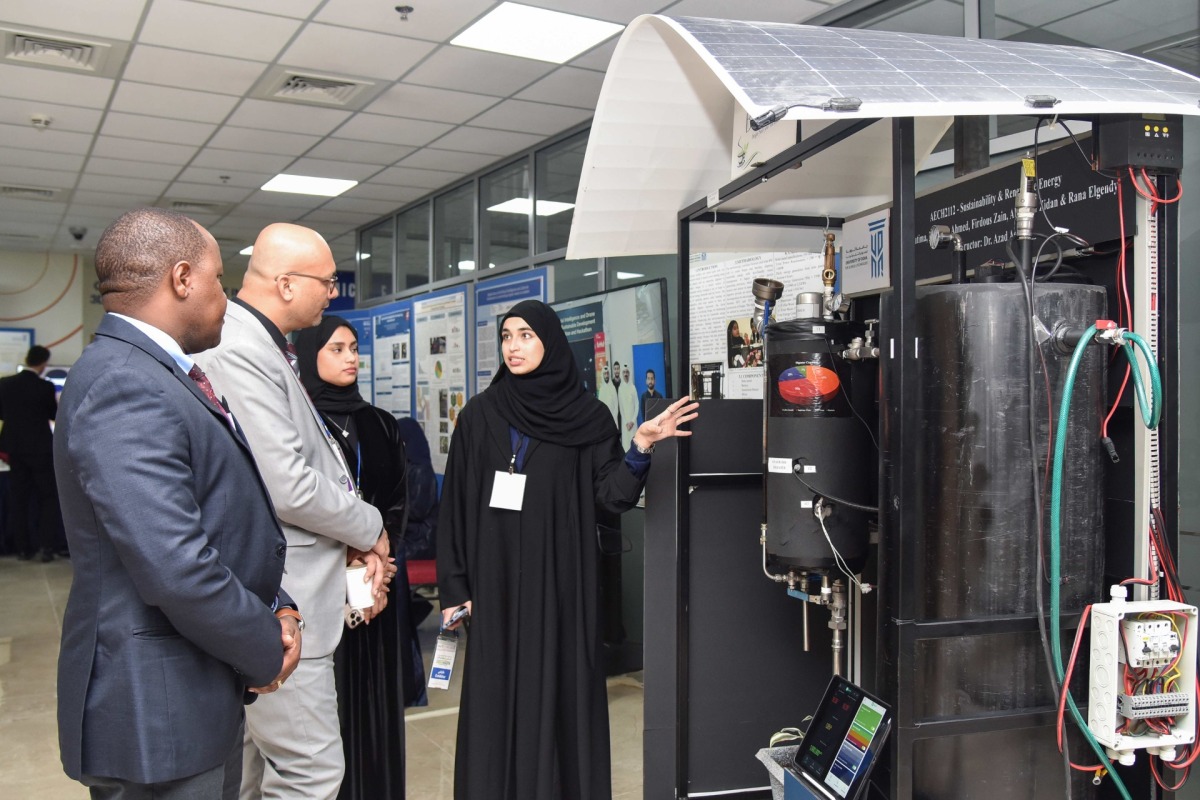 UDST students demonstrating a pilot scale setup for the production of biogas from organic waste. 