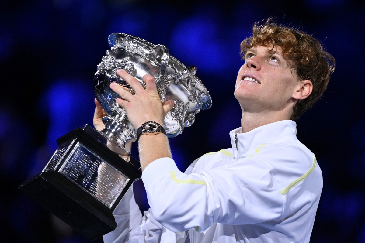 Italy's Jannik Sinner celebrates with the Norman Brookes Challenge Cup trophy after defeating Germany's Alexander Zverev during their men's singles final match on day fifteen of the Australian Open tennis tournament in Melbourne on January 26, 2025. (Photo by WILLIAM WEST / AFP)