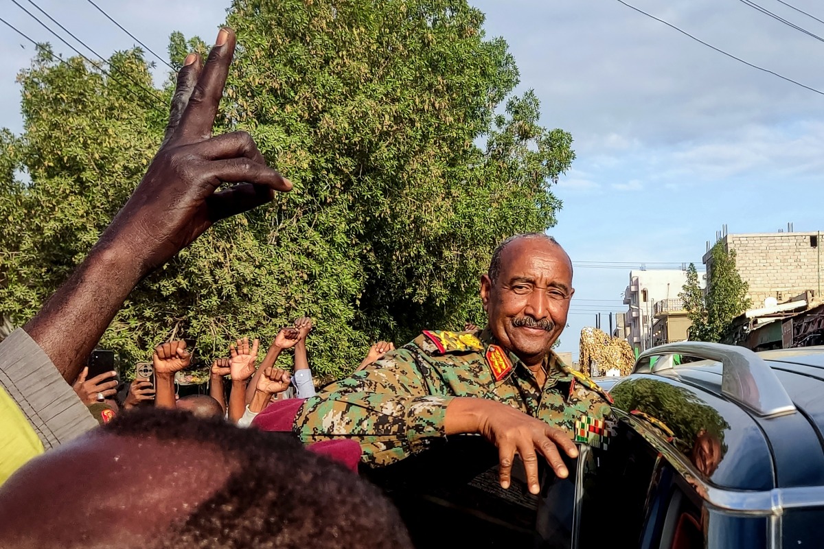 (FILES) People cheer as Sudan's de facto leader, armed forces chief Abdel Fattah al-Burhan arrives at the market in Port Sudan on December 29, 2024. (Photo by AFP)
