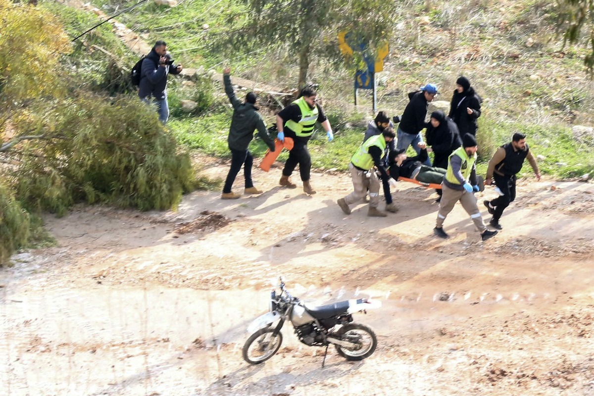 Rescuers in Chaqra carry an injured person shot by Israeli soldiers on January 26, 2025. (Photo by Mahmoud ZAYYAT / AFP)
