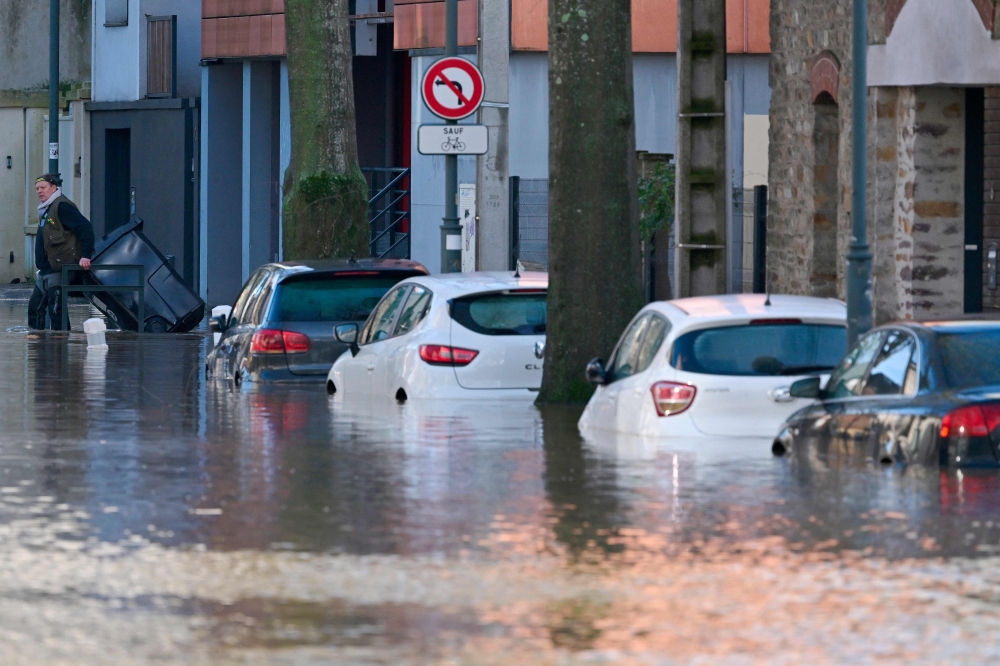 This photograph shows cars in a street following exceptional floodin of the Ille river in Rennes, western France on January 27, 2025. (Photo by Damien Meyer / AFP)