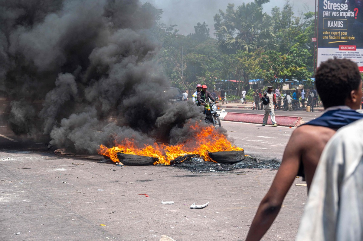 Burning tires block a road during a demonstration against the escalating conflict in eastern Democratic Republic of Congo in Kinshasa, on January 28, 2025. (Photo by Hardy BOPE / AFP)
