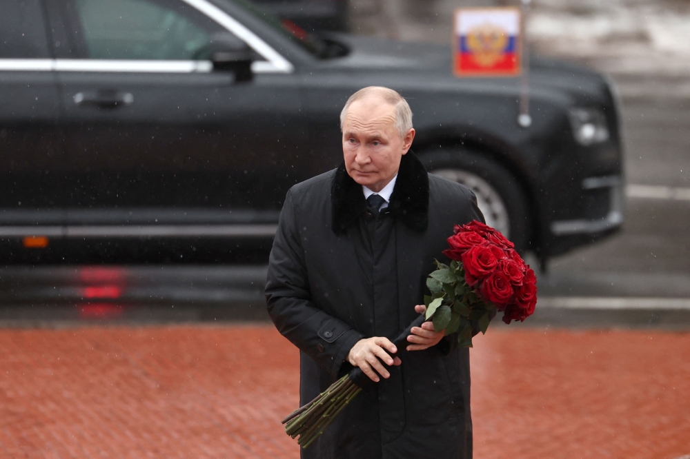 In this pool photograph distributed by the Russian state agency Sputnik, Russian President Vladimir Putin lays flowers at the monument 'Rubezhny Kamen' (Boundary Stone) in Kirovsk, Leningrad region, on January 27, 2025, marking the 81st anniversary of the liberation of Leningrad from Nazi blockade in World War Two. (Photo by Vyacheslav Prokofyev / POOL / AFP)