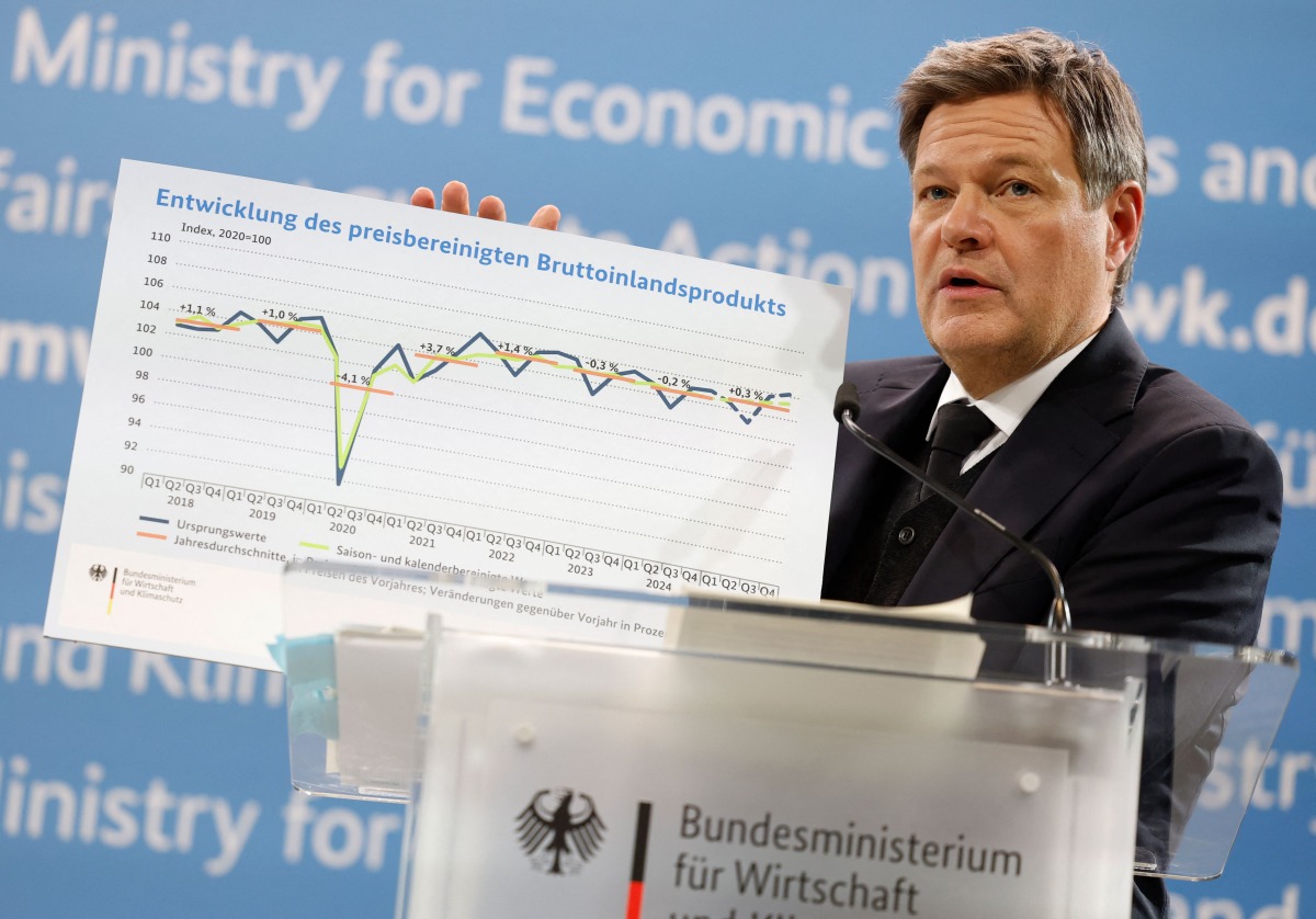 German Minister of Economics and Climate Protection Robert Habeck holds a graphic depicting the development of Germany's price-adjusted gross domestic product as he addresses a press conference to present the annual economic report 2025 at his ministry in Berlin on January 29, 2025. (Photo by Odd ANDERSEN / AFP)