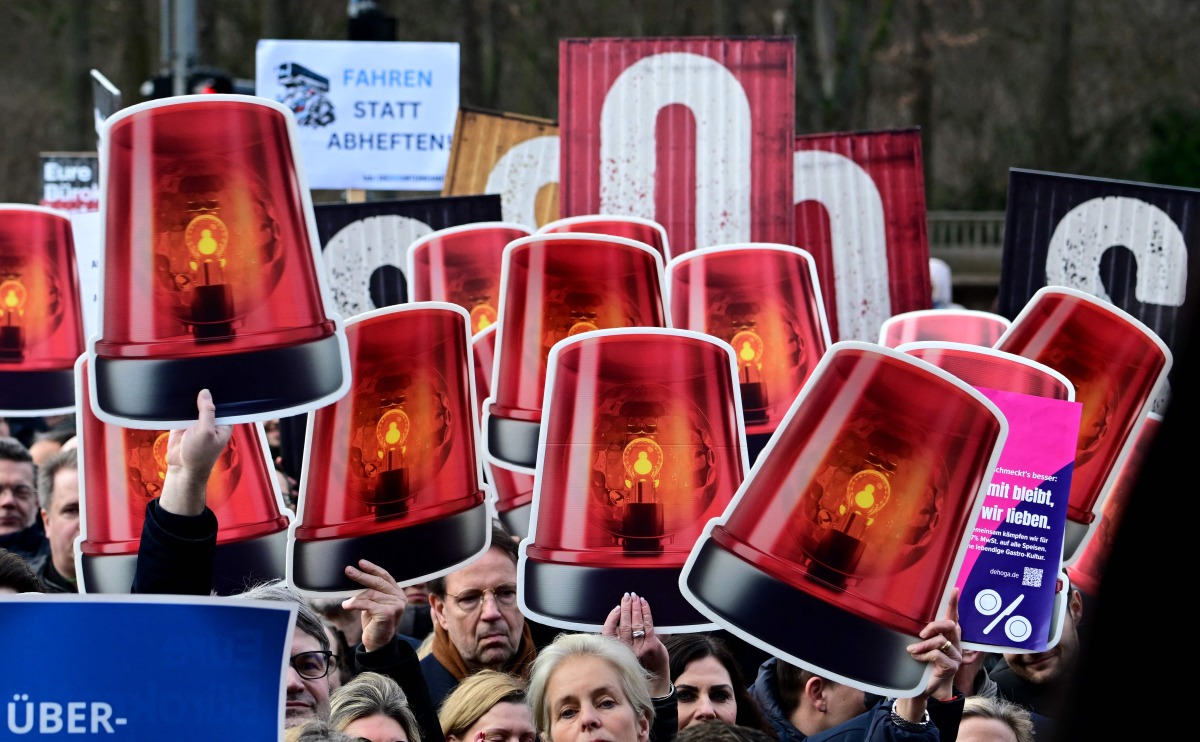 Demonstrators take part in a rally during a nationwide so-called Economic Warning Day (Wirtschaftswarntag) on January 29, 2025 in Berlin, as more than 140 associations and over 200 companies from all over Germany are jointly calling on politicians to take measures in order to ensure the country's economic stability. (Photo by Tobias SCHWARZ / AFP)
