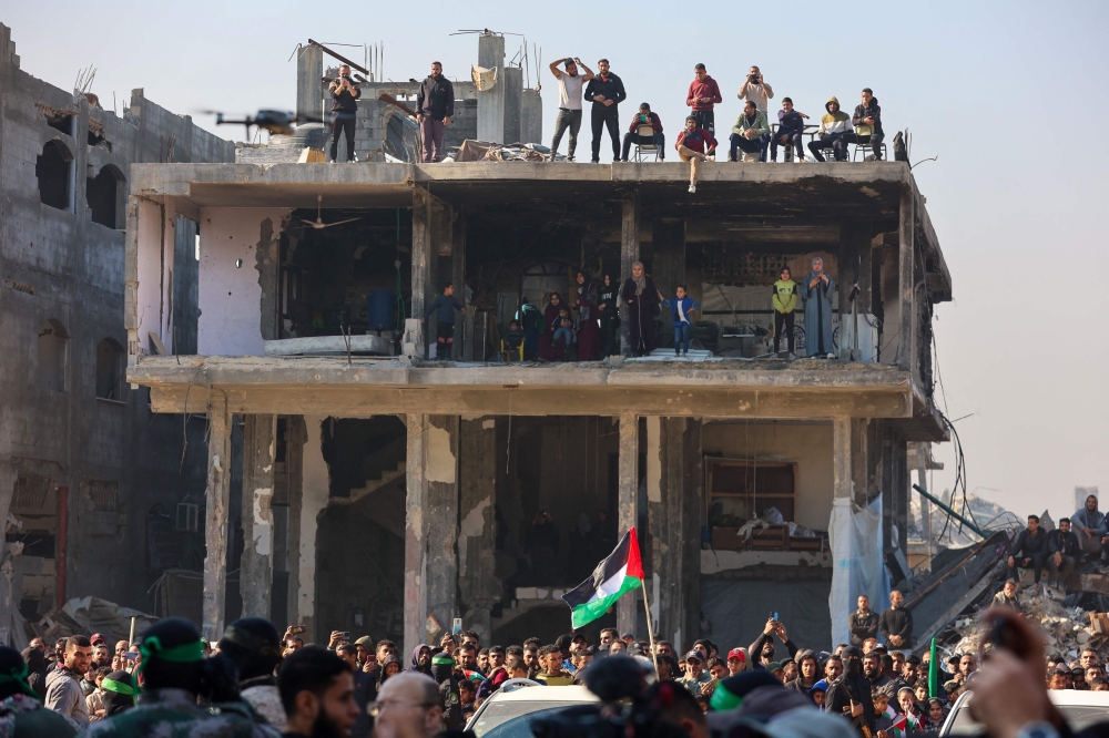 Gazans gather to watch as Hamas prepares to hand over Israeli hostage to a Red Cross team in Jabalia on January 30, 2025. (Photo by Omar Al-Qattaa / AFP)