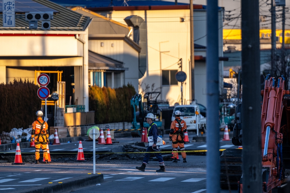 Rescue operations continue for a truck driver after his vehicle plunged into a sinkhole at in Yashio, Saitama Prefecture on January 30, 2025. (Photo by Philip Fong / AFP)