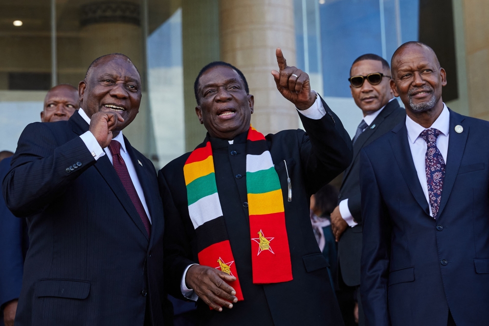 (From left) South African President Cyril Ramaphosa, President of Zimbabwe and SADC Chairman Emmerson Mnangagwa and SADC Executive Secretary Elias Magosi gesture ahead of the Southern African Development Community (SADC) extraordinary summit in Harare on January 31, 2025.  (Photo by Jekesai Njikizana / AFP)