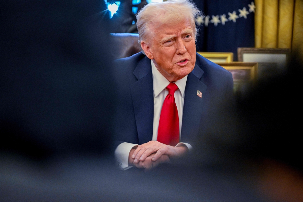 US President Donald Trump speaks to the press after signing an executive order in the Oval Office of the White House on January 30, 2025 in Washington, DC. (Photo by Roberto Schmidt / AFP)