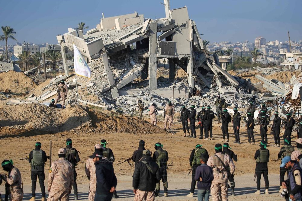 Hamas secures an area before handing over two Israeli hostages to a Red Cross team in Khan Yunis on February 1, 2025. (Photo by Eyad Baba / AFP)