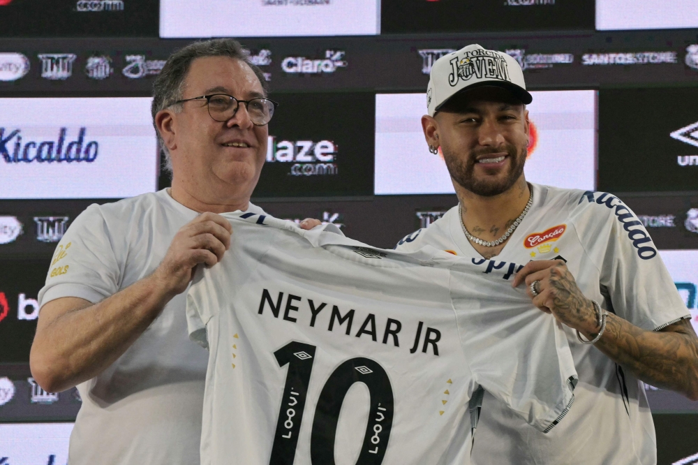 Brazilian football star Neymar (R) and the President of Santos, Marcelo Pirilo Teixeira, at the Urbano Caldeira Stadium in Santos, Sao Paulo state, Brazil on January 31, 2025. (Photo by NELSON ALMEIDA / AFP)