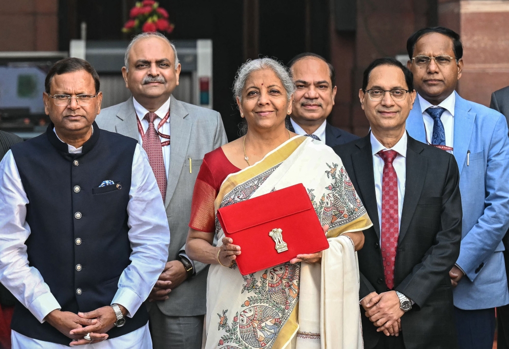 India's Finance Minister Nirmala Sitharaman (C) along with minister of state for finance Pankaj Chaudhary (C, left) poses as she leaves the ministry of finance to present the annual budget at the parliament in New Delhi on February 1, 2025. (Photo by Money Sharma / AFP)