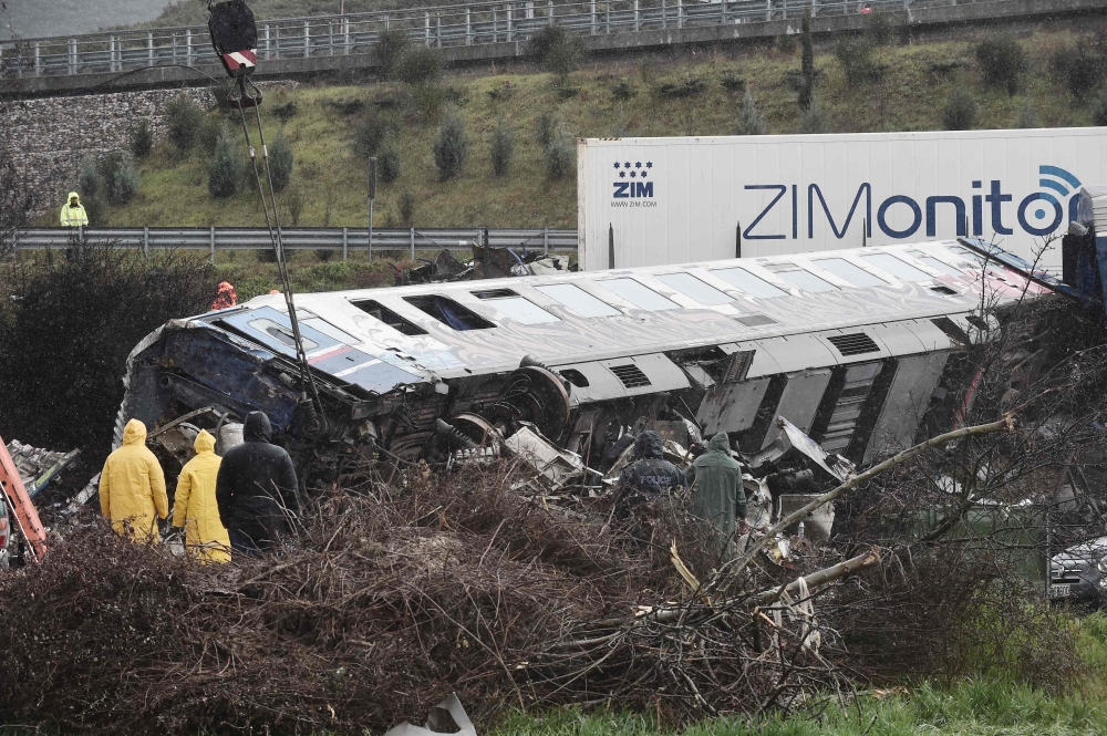 Police and emergency crews search through the debris of a crushed wagon for second day after a train accident in the Tempi Valley near Larissa, Greece, March 2, 2023. (Photo by Sakis MITROLIDIS / AFP)