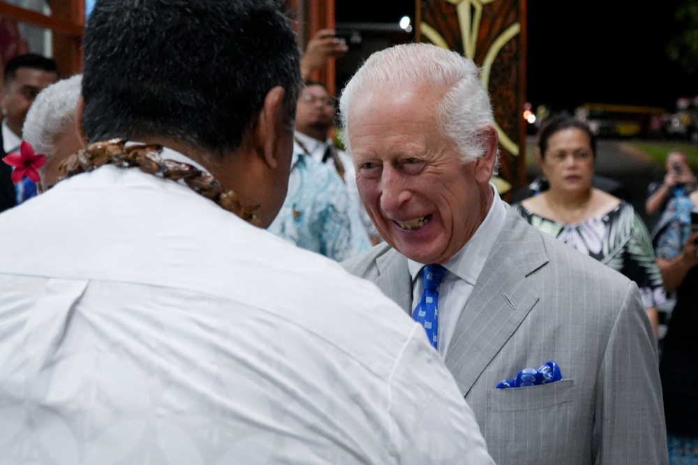 Britain's King Charles III speaks to dignitaries as he arrives at Apia Airport for the Commonwealth Heads of Government Meeting (CHOGM) in Apia, capital of Samoa, on October 23, 2024. (Photo by POOL / AFP)