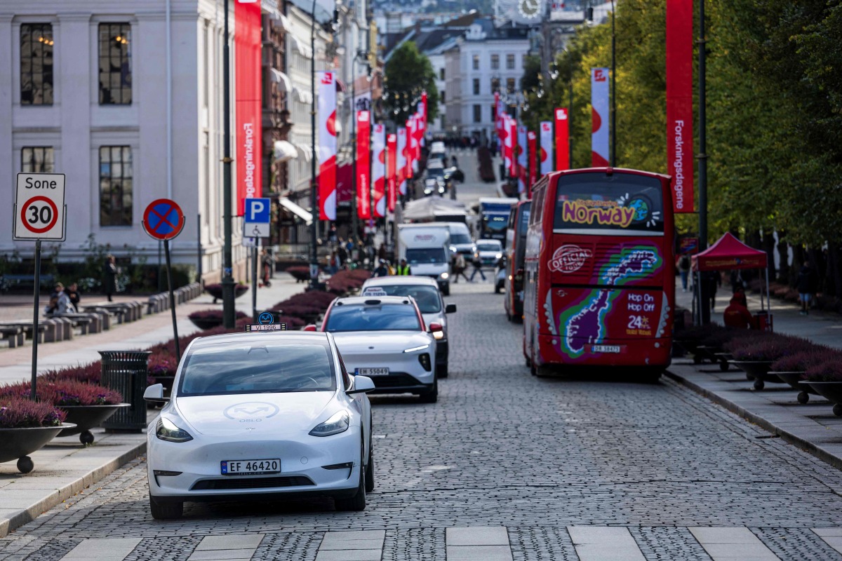 (FILES) Oslo Taxi's Tesla model Y (L) and the NIO ET5 electric vehicle from Nio Inc, a Chinese multinational electric car manufacturer, drive through the Norwegian capital Oslo, on September 27, 2024. (Photo by Jonathan NACKSTRAND / AFP)
