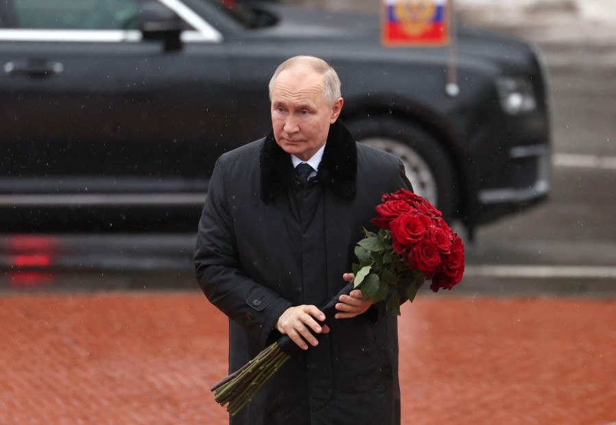 In this pool photograph distributed by the Russian state agency Sputnik, Russian President Vladimir Putin lays flowers at the monument 'Rubezhny Kamen' (Boundary Stone) in Kirovsk, Leningrad region, on January 27, 2025. (Photo by Vyacheslav Prokofyev / POOL / AFP)