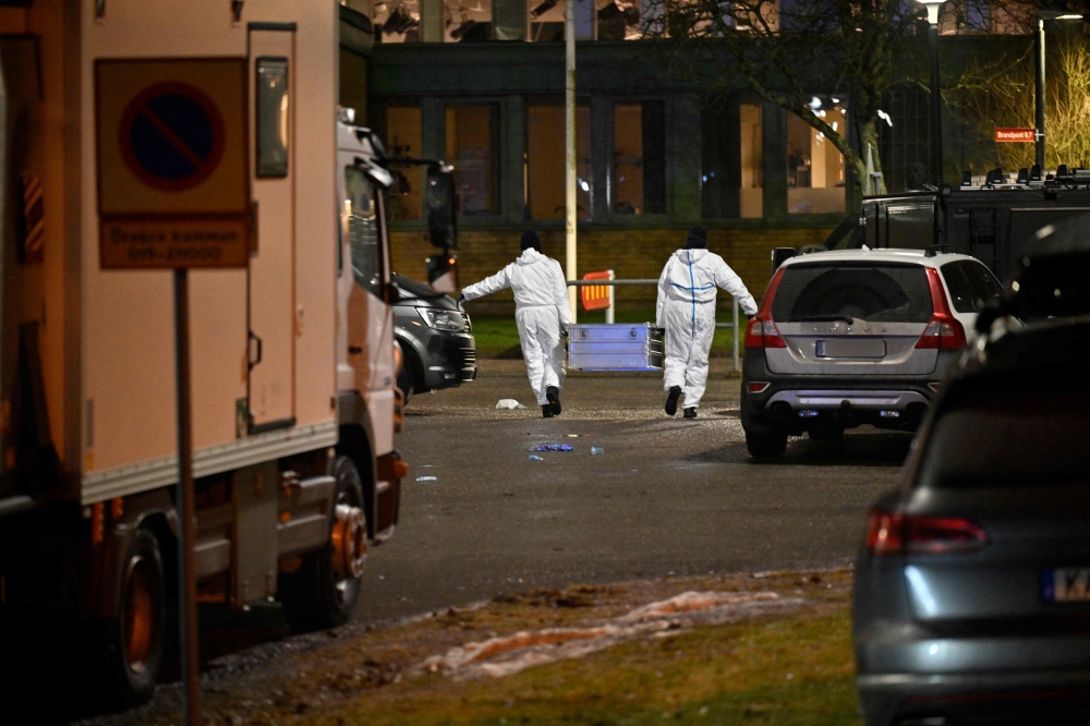 Forensic police officers work at the scene of the Risbergska School in Orebro, Sweden, on February 4, 2025, following reports of a serious violent crime. (Photo by Pontus Lundahl / TT News Agency / AFP) 