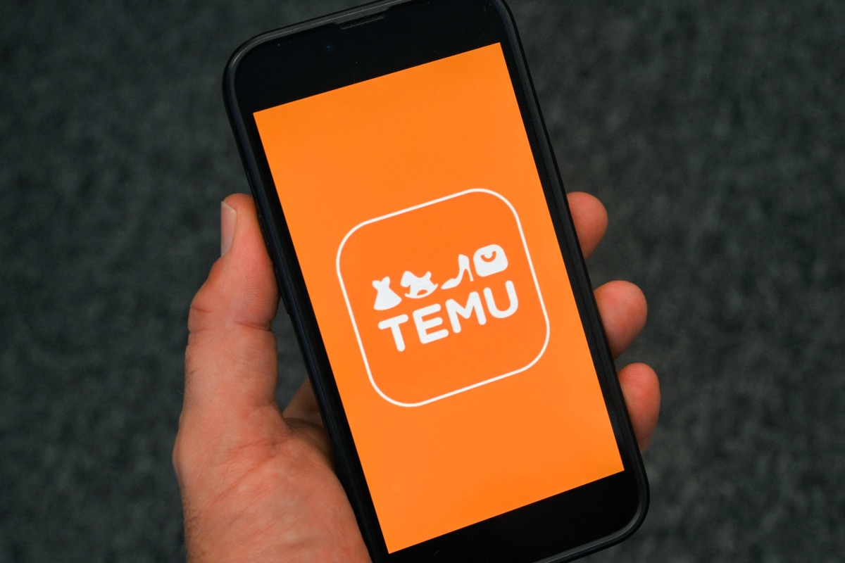 This photo illustration shows the logo of fast fashion e-commerce company Temu displayed on a mobile phone in Brussels, on November 4, 2024. Photo by Nicolas TUCAT / AFP