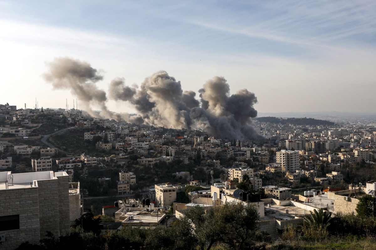 Smoke billows from the site of several explosions during an Israeli raid on the Jenin camp for Palestinian refugees on February 2, 2025. (Photo by MOHAMMAD MANSOUR / AFP)
