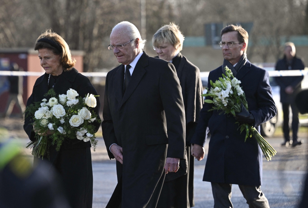 From left: Sweden's Queen Silvia and King Carl XVI Gustaf of Sweden, Prime Minister Ulf Kristersson with his wife Birgitta Ed arrive at the memorial to place flowers outside the adult education center Campus Risbergska school in Orebro, Sweden, on February 5, 2025. (Photo by Jonathan Nackstrand / AFP)