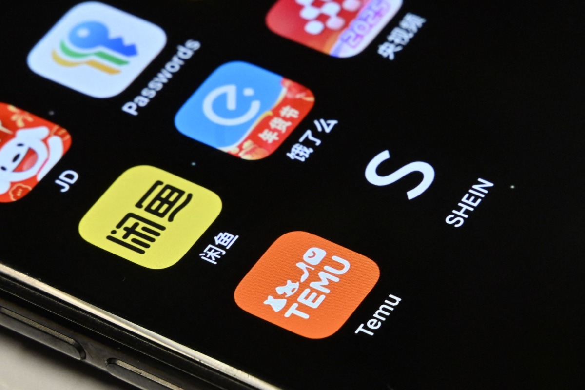 This photo illustration taken on February 5, 2025 shows the Temu and Shein e-commerce apps (front L and R respectively) on a mobile phone in Beijing. Photo by ADEK BERRY / AFP