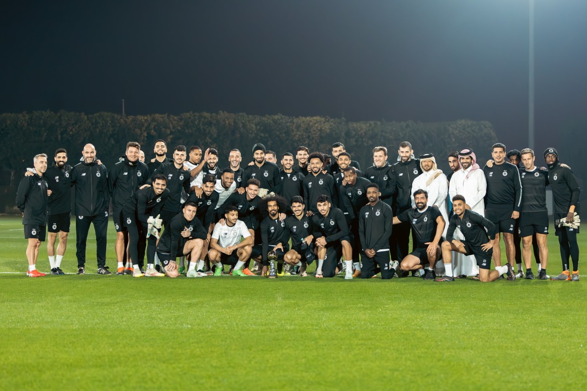 Al Sadd's Akram Afif poses with teammates and officials along with the AFC Player of the Year trophy.