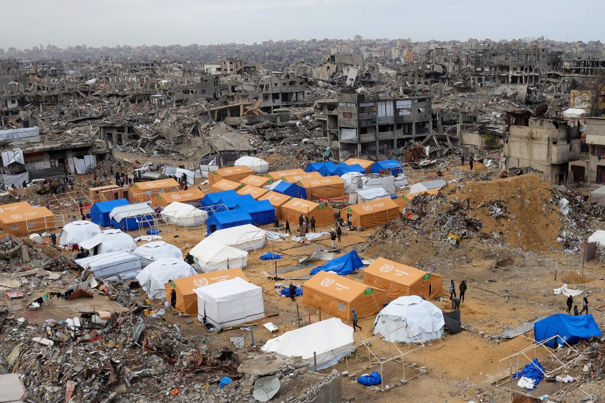 Palestinians walk around their tents, set up amid heavily damaged buildings in Jabalia, in the northern Gaza Strip, on February 6, 2025. (Photo by Bashar TALEB / AFP)
