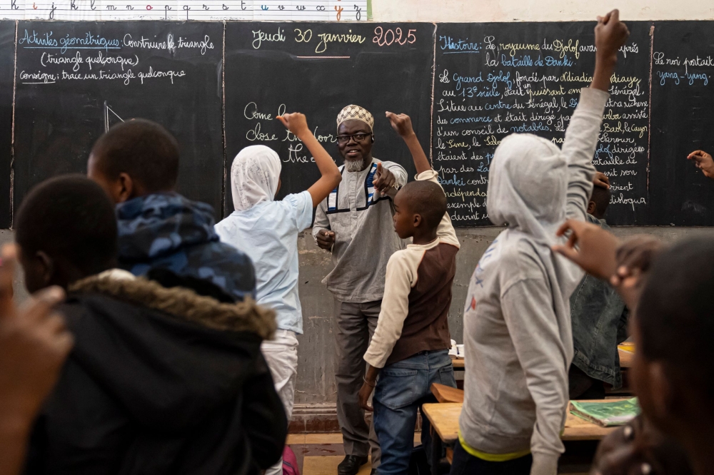 An English teacher points to a student after asking a question during English class at Alassane Ndiaye Allou Primary School in Dakar, on January 30, 2025. (Photo by PATRICK MEINHARDT / AFP)