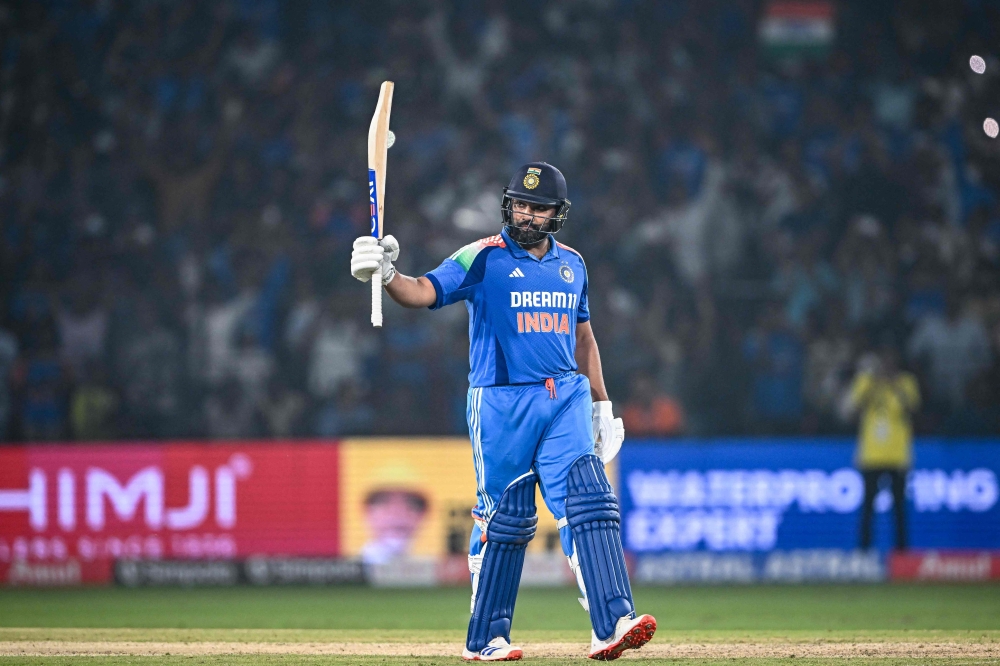 India's captain Rohit Sharma celebrates after scoring a century (100 runs) during the second one-day international (ODI) cricket match between India and England at the Barabati Stadium in Cuttack on February 9, 2025. (Photo by Dibyangshu Sarkar / AFP)