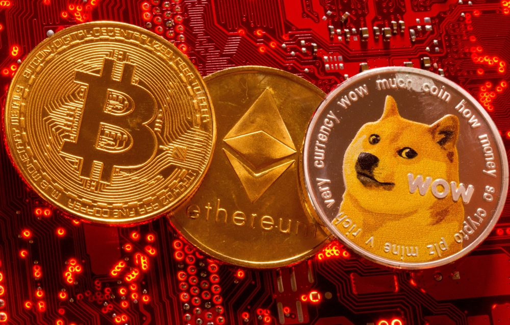 File photo: Representations of Cryptocurrencies Bitcoin, Ethereum and DogeCoin are placed on PC motherboard in this illustration taken, June 29, 2021. (REUTERS/Dado Ruvic)