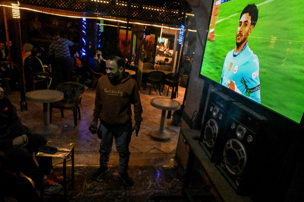 Men watch UEFA Champions League match Manchester City against Real Madrid, at a cafe in Cairo on February 11, 2025. (Photo by Khaled Desouki / AFP)