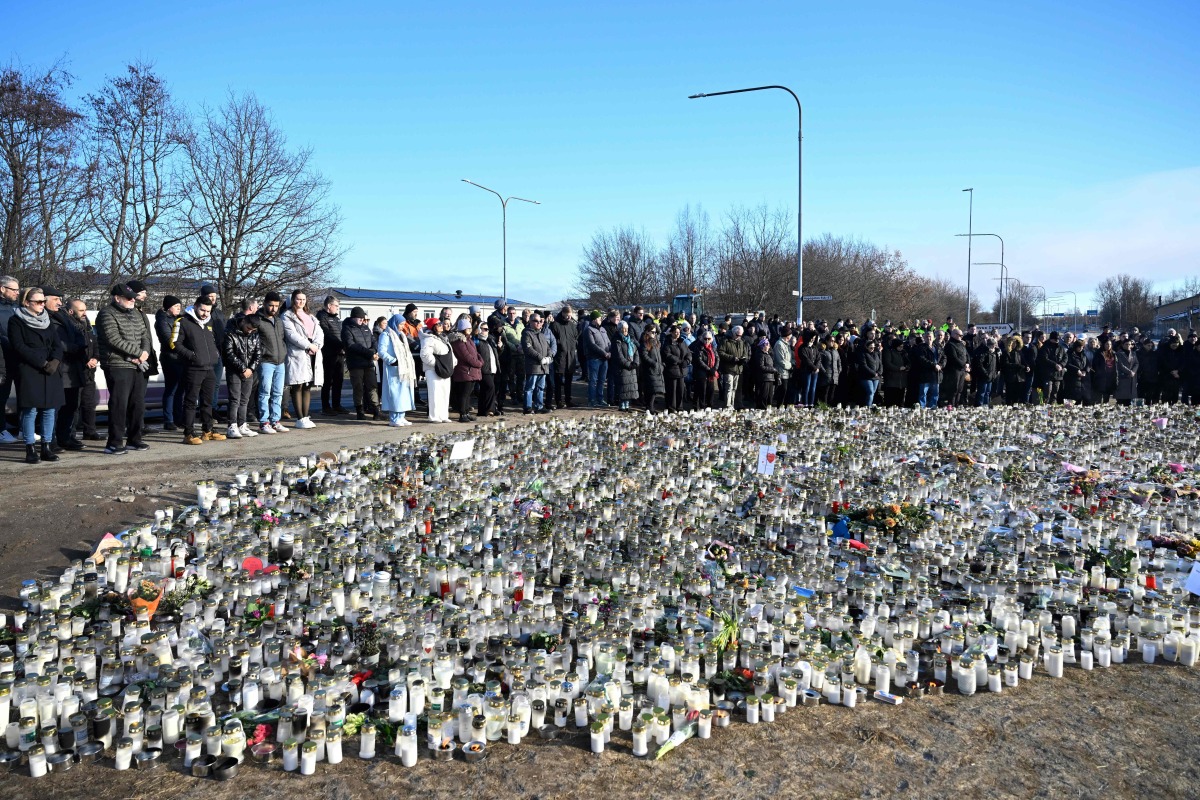 People gather at a makeshift memorial to observe a national minute's silence to honor the victims of the February 4 school shooting in Orebro, Sweden on February 11, 2025. (Photo by Jessica GOW / TT News Agency / AFP) / Sweden OUT
