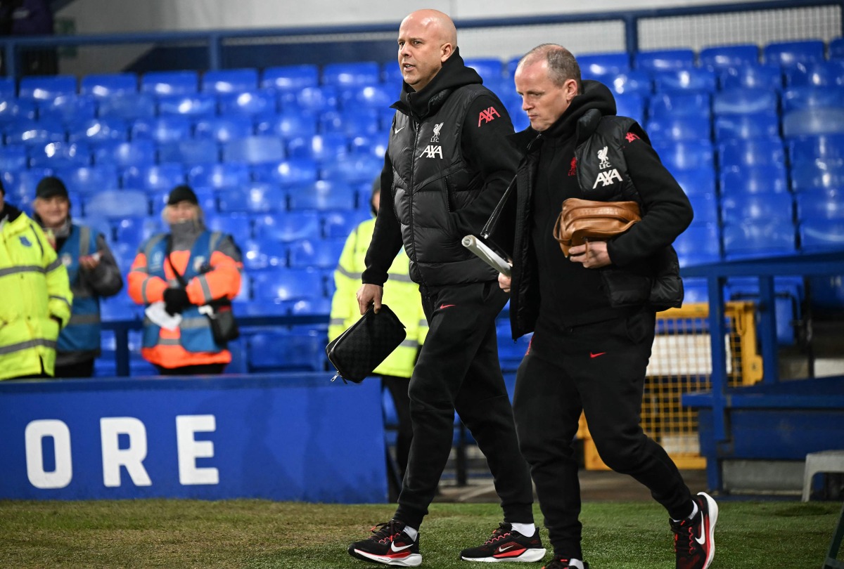 Liverpool's Dutch manager Arne Slot (L) walks on the pitch ahead of the English Premier League football match between Everton and Liverpool at Goodison Park in Liverpool, north west England on February 12, 2025. (Photo by Paul ELLIS / AFP)