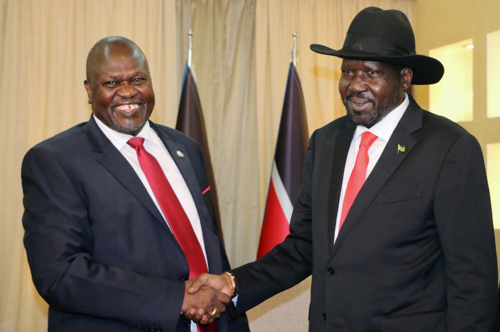 FILE PHOTO: South Sudan's President Salva Kiir shakes hands with ex-vice president and former rebel leader Riek Machar during their meeting in Juba, South Sudan, October 19, 2019. REUTERS/Jok Solomun/File Photo