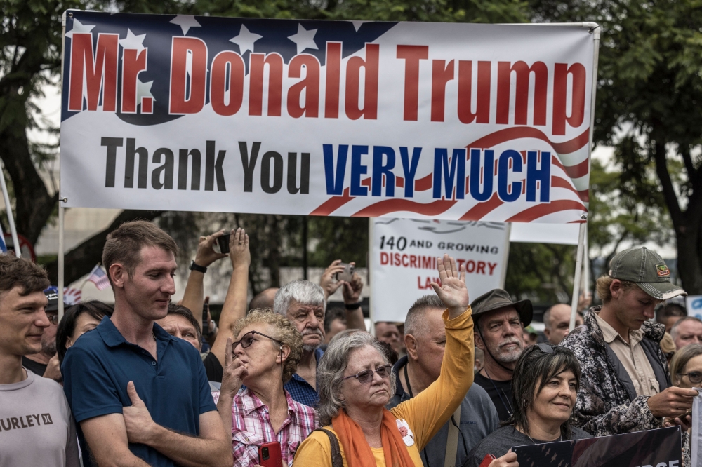 White South Africans supporting US President Donald Trump and South African and US tech billionaire Elon Musk gather in front of the US Embassy in Pretoria. (Photo by Marco Longari / AFP)