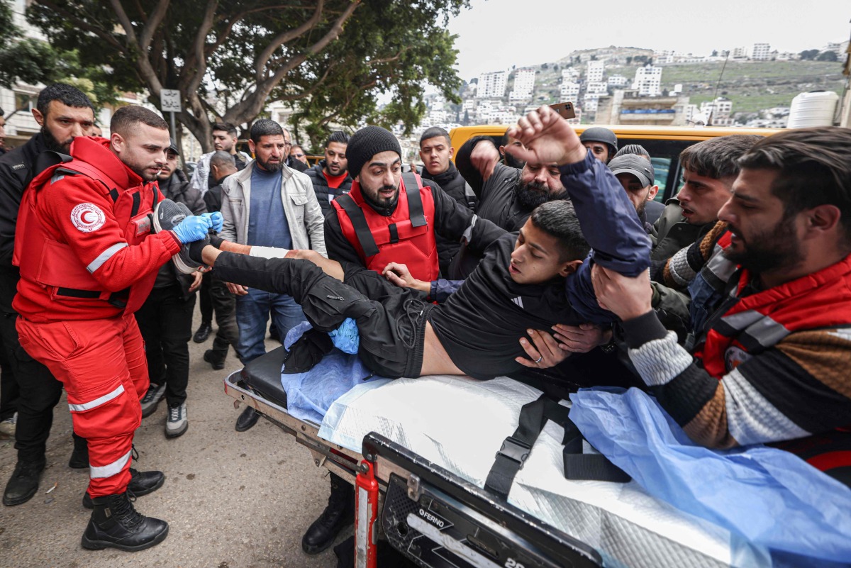 Paramedics transport a youth injured during a military raid in the old town of Nablus in the occupied West Bank on February 16, 2025. (Photo by JAAFAR ASHTIYEH / AFP)
