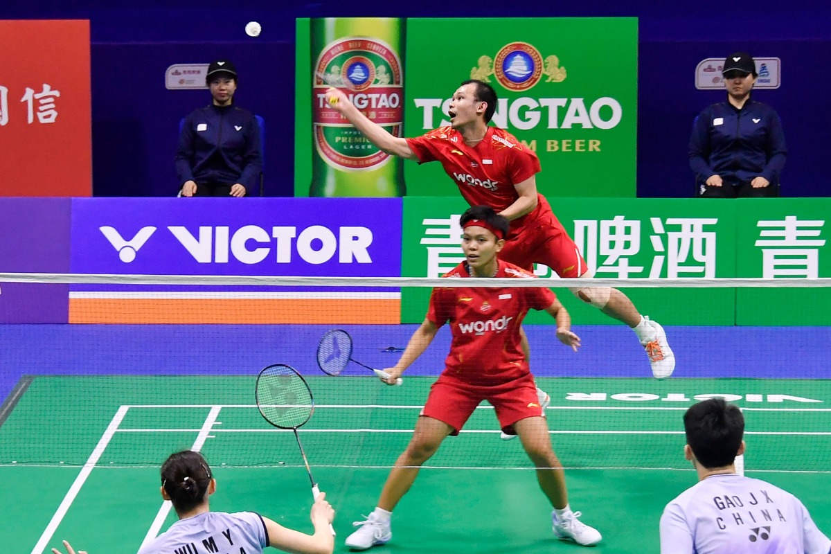 Indonesia's Siti Fadia Silva Ramadhanti (C) and Rinov Rivaldy (top) play a point during their mixed doubles match against China's Gao Jiaxuan (R) and Wu Mengying (L) at the Badminton Asia Mixed Team Championships in Qingdao, in China's eastern Shandong province on February 16, 2025. (Photo by AFP)